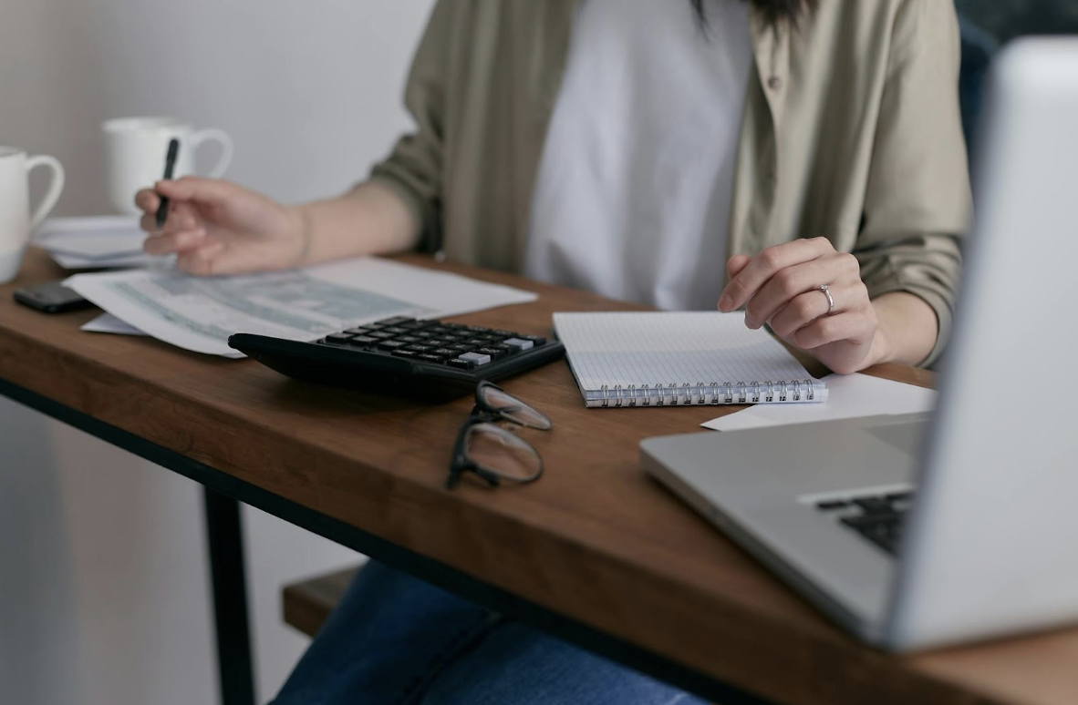 Woman Sitting at a Desk and Balancing the Business Books